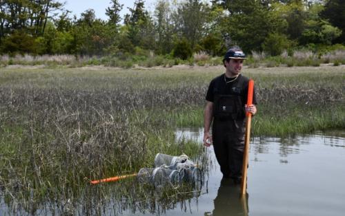 Charles Heyder standing in the water with fish traps