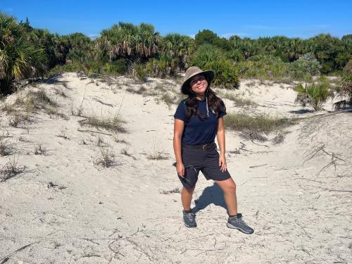 Krystal on a sunny beach with palmetto in the background