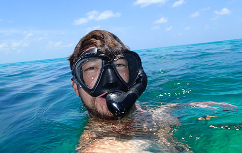 Travis Knorr in the water wearing a mask and snorkle