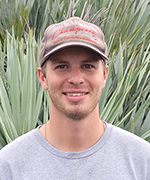 A picture of Jonathan Marshall in front of palm fronds